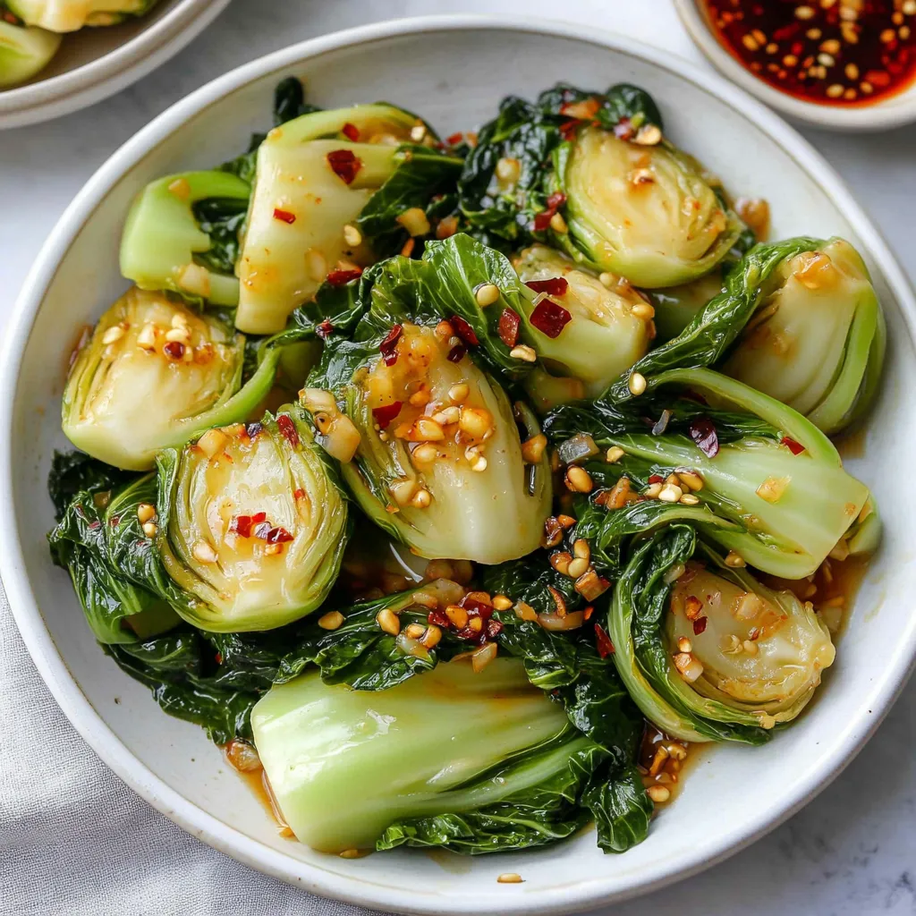 A bowl of greens with nuts and sauce.