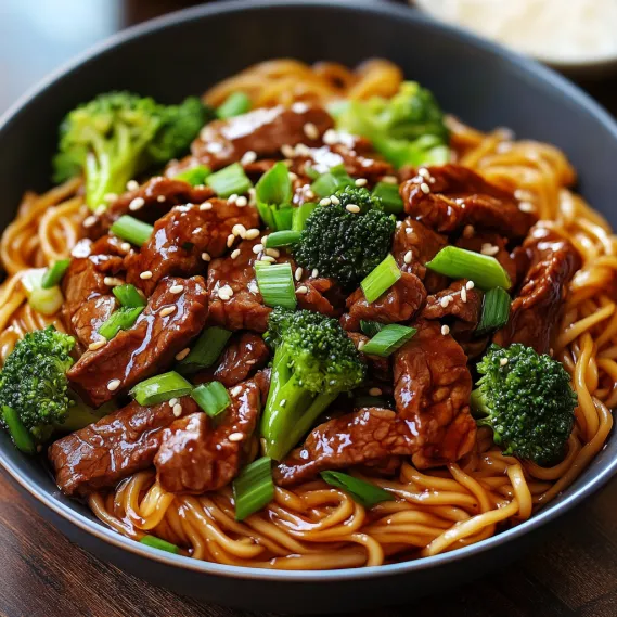 A bowl of Chinese food with broccoli and meat.