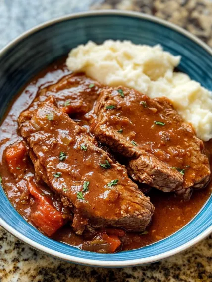 A bowl of meat and potatoes.