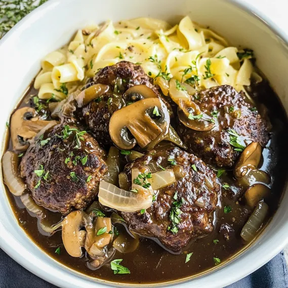 A bowl of pasta with meatballs and mushrooms.