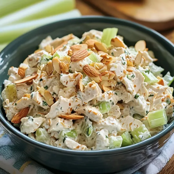 A bowl of food with almonds and cucumbers.