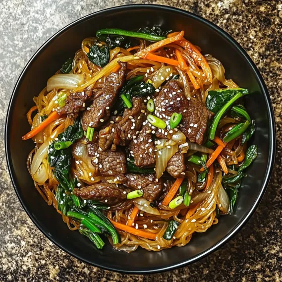 A dish of stir-fried noodles with vegetables and beef.