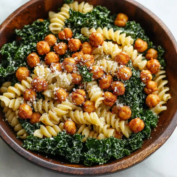 A bowl of pasta with chickpeas and spinach.